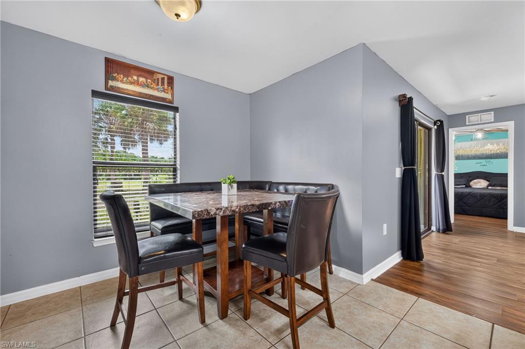 Dining area featuring tile flooring, a window with horizontal blinds, and a built-in bench seating unit