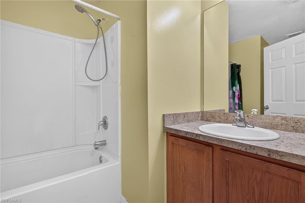 Bathroom featuring a shower/tub combination with white surround, a chrome showerhead, and a single-handle faucet