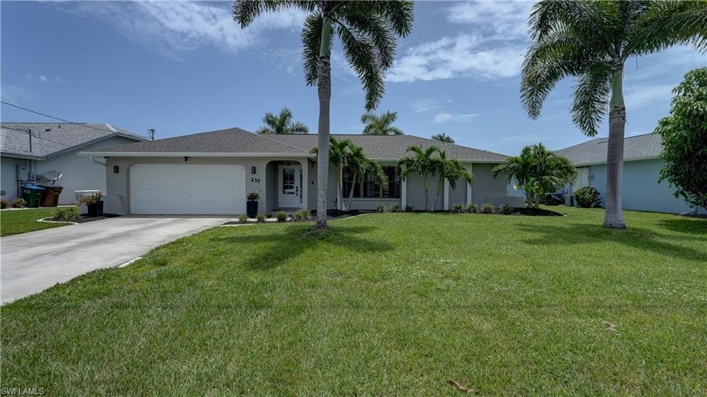 Single-story residence featuring a gray exterior, a two-car garage, a covered front entry, and a well-maintained front lawn