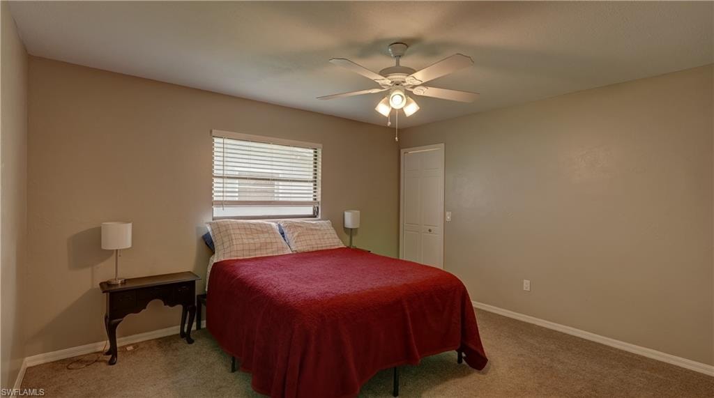Room featuring neutral wall tones, textured carpeting, and a ceiling fan with integrated lighting
