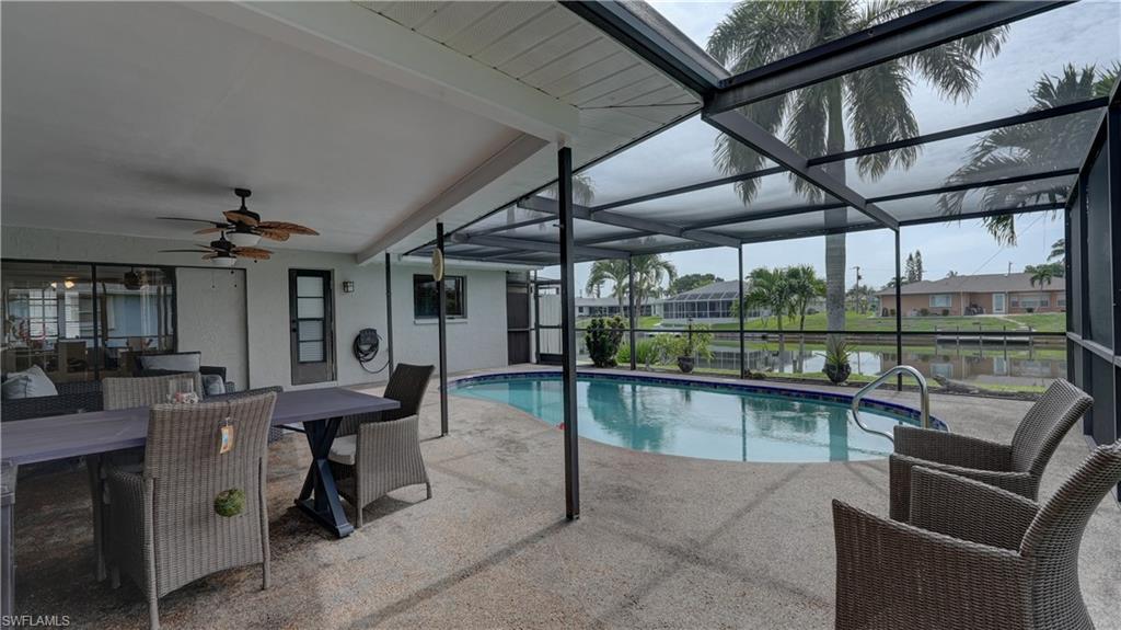 Screened-in patio with an in-ground swimming pool, concrete decking, and waterfront access