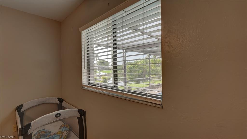 Interior room featuring a single window with horizontal blinds, offering a partial exterior view