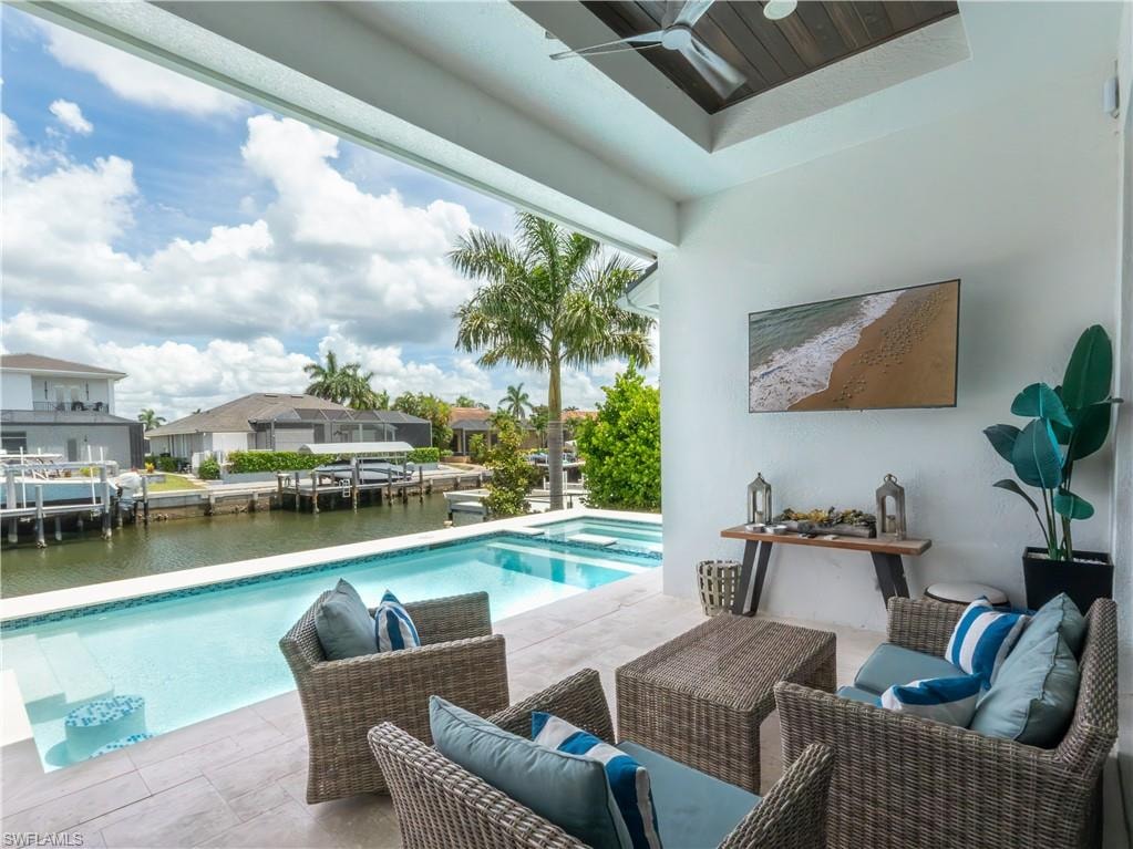Waterfront poolside retreat featuring a resort-style saltwater pool with integrated lounging areas, composite decking, woven rattan seating with cushioned elements, and a covered loggia with skylights