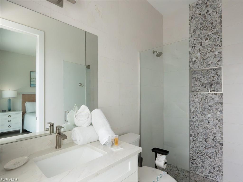 Modern bathroom featuring a floating vanity with rectangular vessel sink, polished nickel fixtures, and quartz countertop