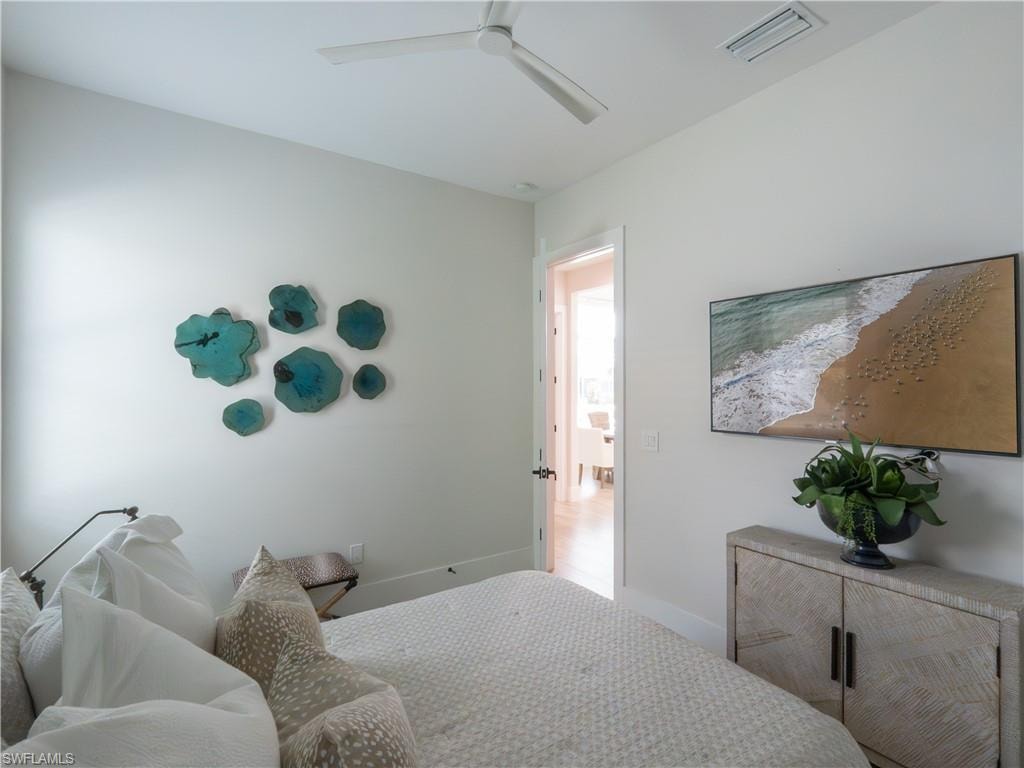 Serene primary bedroom featuring soft neutral finishes, recessed ceiling lighting, and a decorative accent wall displaying sculptural wall art