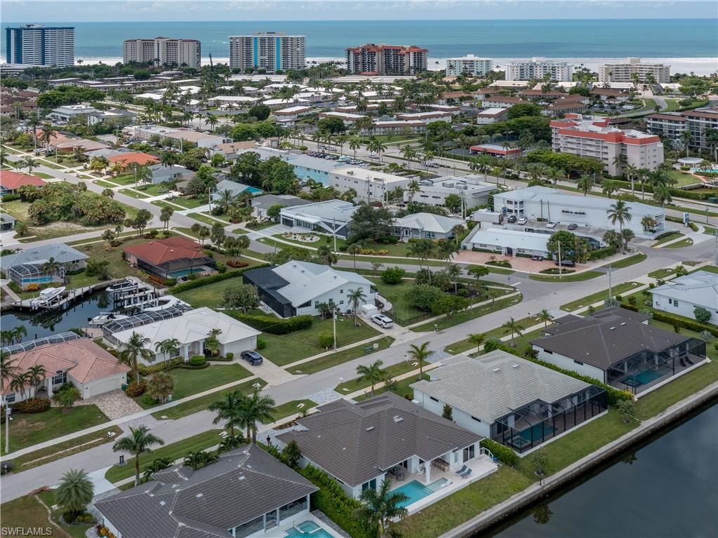Aerial perspective of a waterfront residential area with multiple properties featuring private docks and screened pools