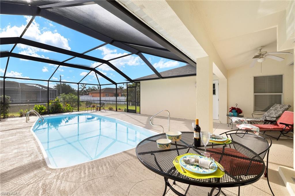 Outdoor pool with a patio area, a sunroom, glass enclosure, and ceiling fan