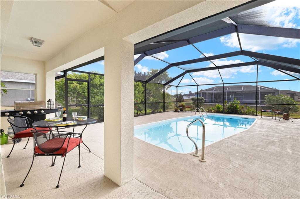 Swimming pool featuring a lanai, a patio area, a sunroom, and area for grilling