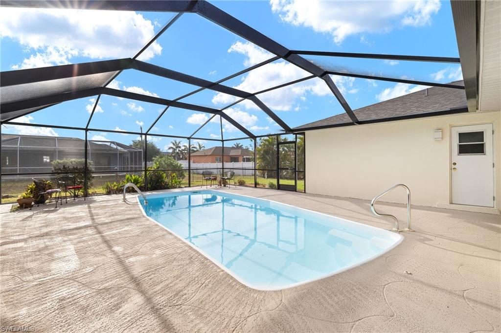 Swimming pool featuring a sunroom, glass enclosure, and a patio