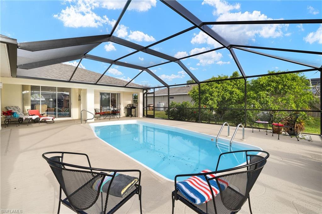 Swimming pool featuring a sunroom, a patio area, a lanai, and area for grilling
