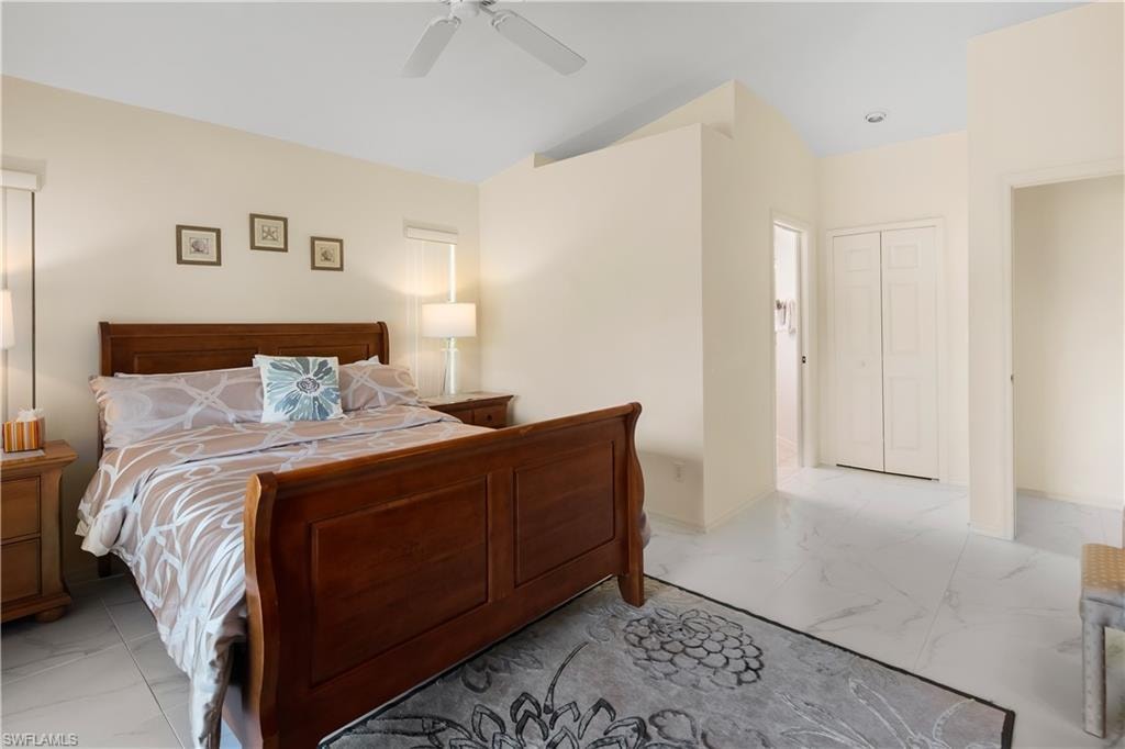 Spacious room featuring vaulted ceilings, a ceiling fan, and large windows with privacy blinds