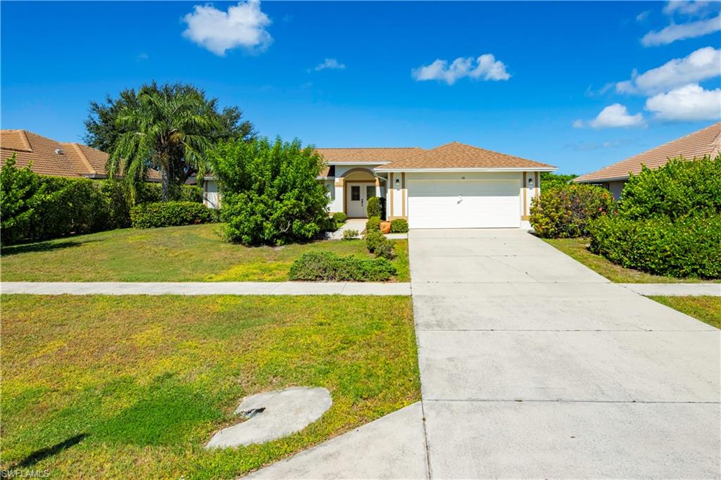 Single-story residence with a concrete driveway, attached two-car garage, and established landscaping