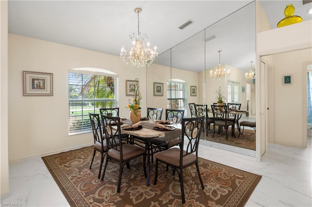 Formal dining area featuring a crystal chandelier and a large mirrored wall