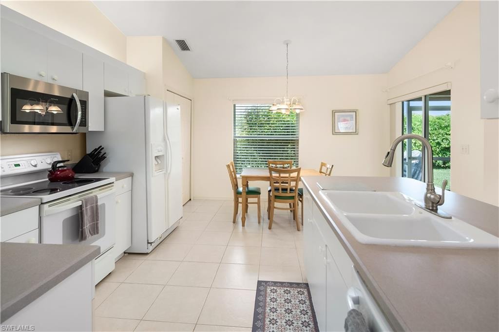 Kitchen featuring white cabinetry, light-toned countertops, and tile flooring