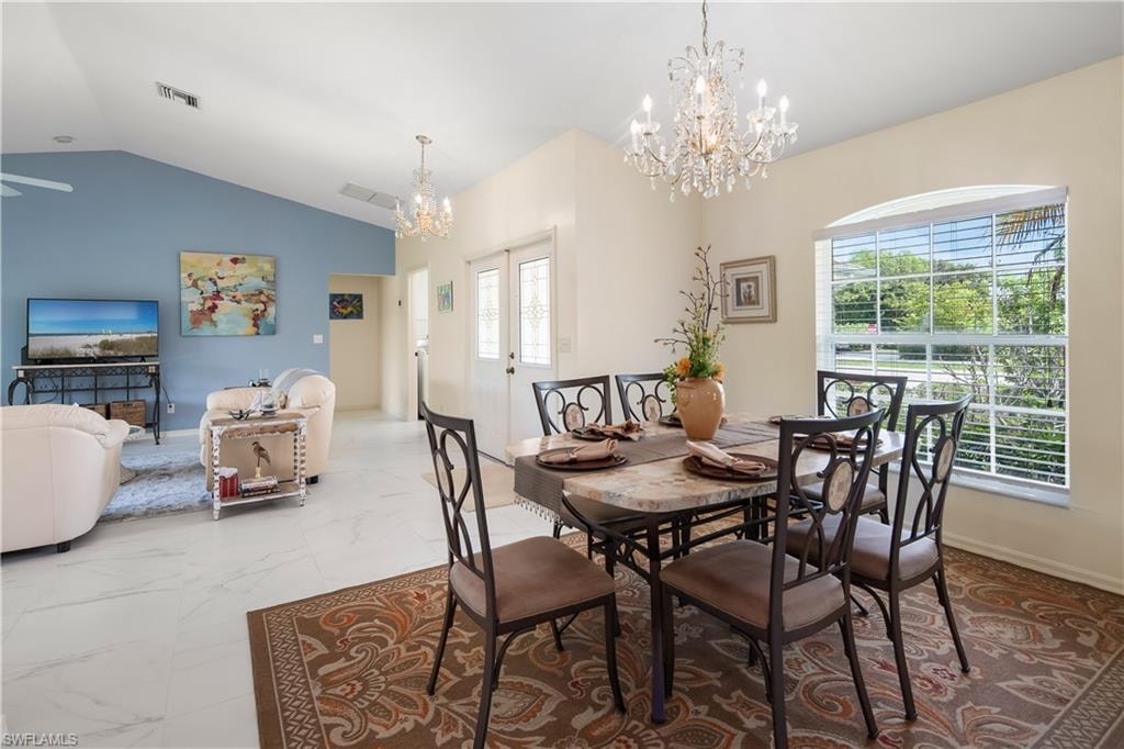 Dining area featuring a crystal chandelier, arched window with horizontal blinds, and a built-in double-door entry