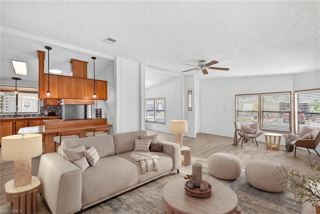 Virtually Staged Open-concept living area featuring light wood-finish flooring and white walls