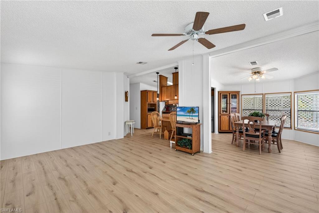 Bright interior space featuring wood-finish flooring, white walls, and ceiling fans