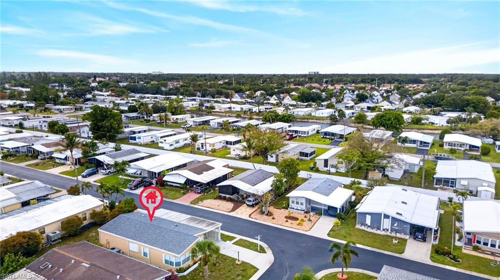 Aerial perspective of a residential neighborhood with visible streets, numerous homes, and mature trees