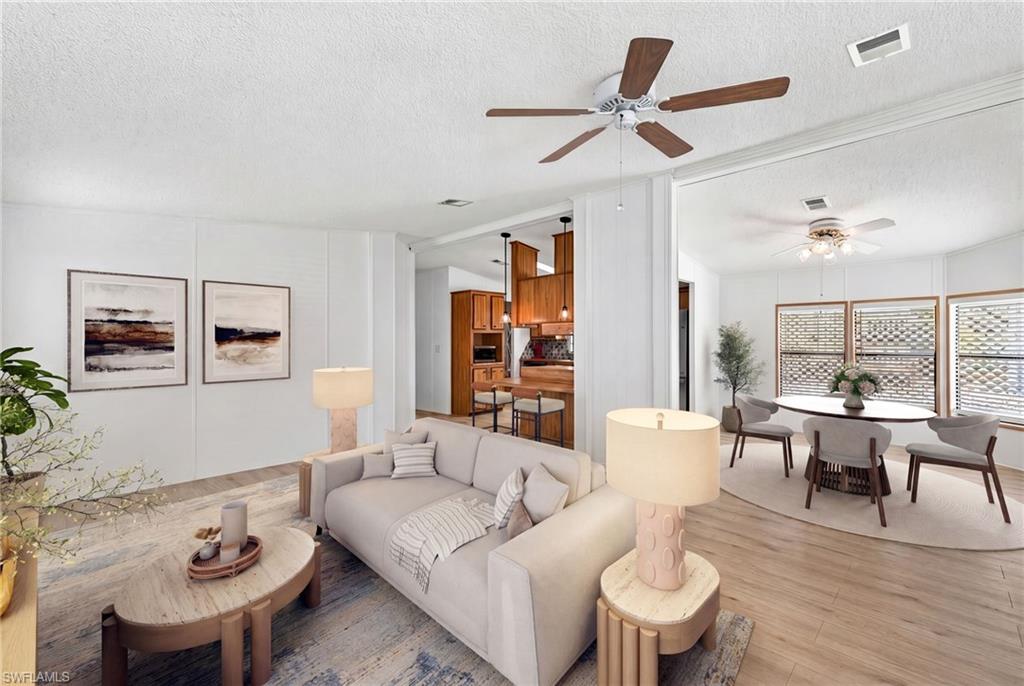 Virtually Staged Spacious living area featuring wood-finish flooring, a ceiling fan, and white paneled walls