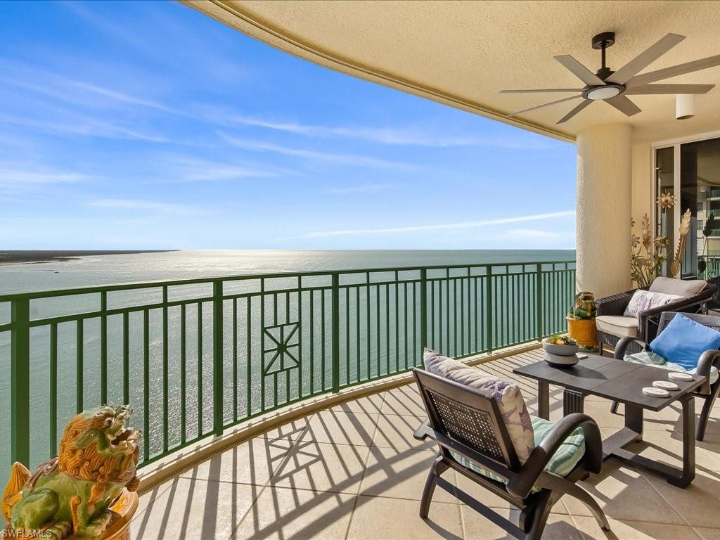 Balcony with ceiling fan, a water view, and an outdoor living space