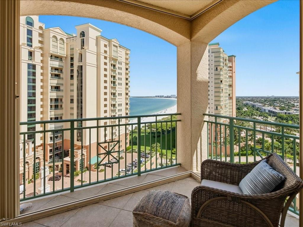 Spacious balcony with tiled flooring and a durable metal railing, offering expansive coastal and urban vistas