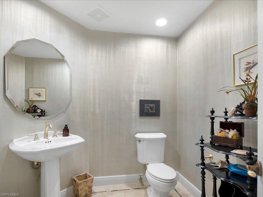 Half bathroom featuring toilet and light tile patterned floors