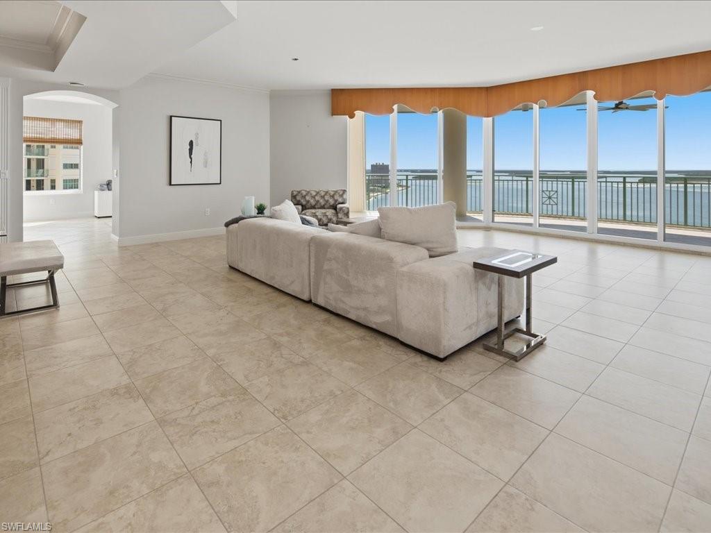 Open-concept living area with expansive floor-to-ceiling windows, showcasing panoramic waterfront scenery