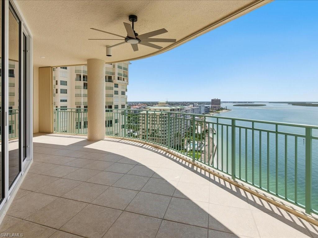Expansive outdoor balcony with tile flooring and a curved green railing