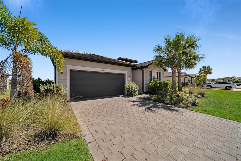 Ranch-style home featuring decorative driveway and a garage