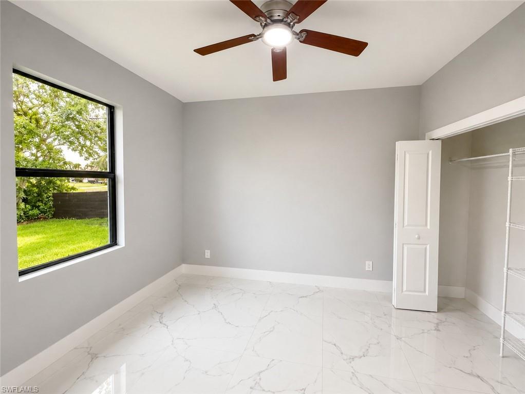 Room featuring large-format porcelain tile flooring, light gray wall paint, and a modern ceiling fan with wood-finish blades
