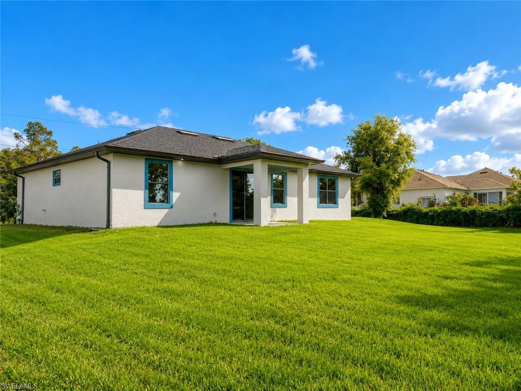 Expansive green lawn surrounds a stucco exterior with a dark shingle roof