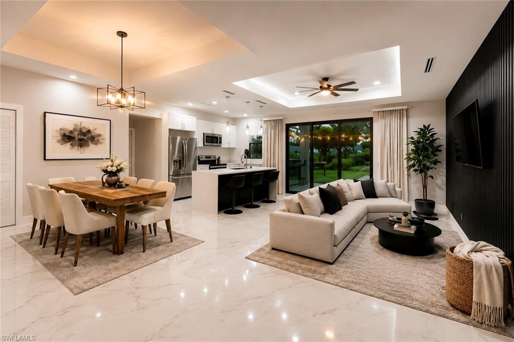 Open-concept living space featuring high ceilings with recessed lighting, large format polished tile flooring, and a contemporary kitchen with stainless steel appliances