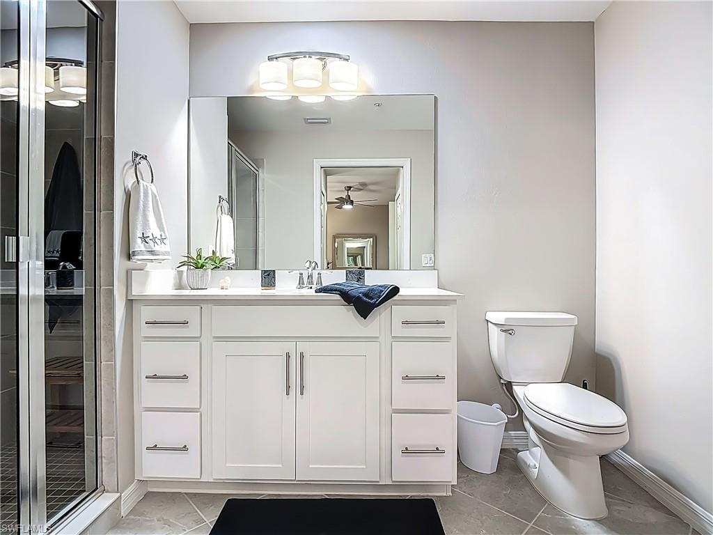Full bathroom with marble finish floors, vanity, a ceiling fan, and an enclosed shower