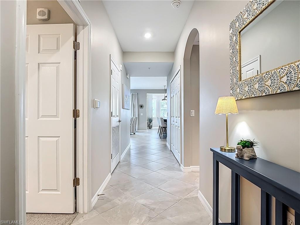 Corridor featuring arched walkways and baseboards