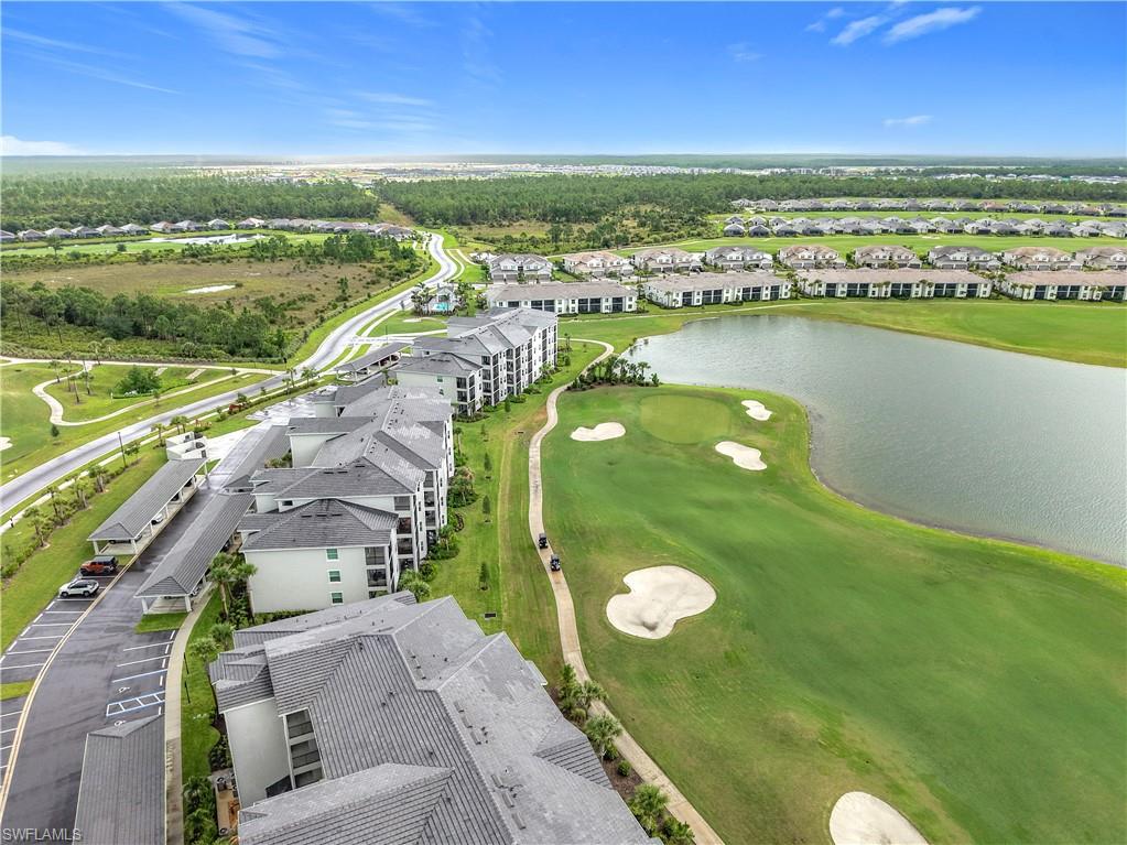 Aerial perspective of suburban area featuring a large body of water and a golf course