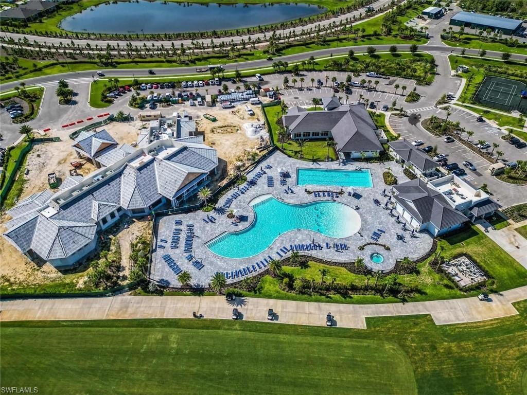 Aerial view of property and surrounding area featuring a pool and a nearby body of water