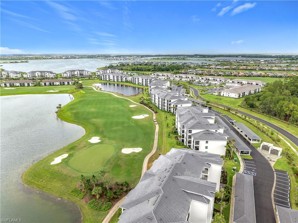 Aerial view of residential area featuring a large body of water and a local golf course