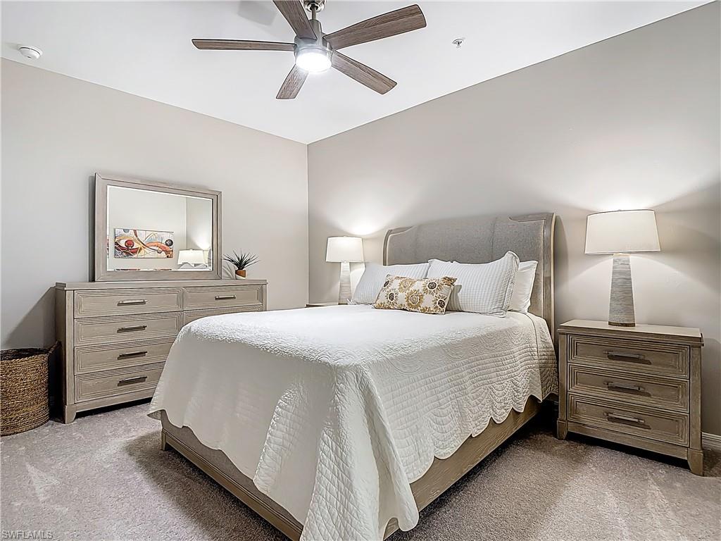 Bedroom with light colored carpet and a ceiling fan
