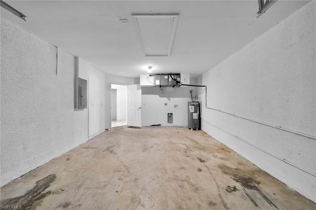 Spacious utility area featuring a water heater, electrical panel, and an access panel