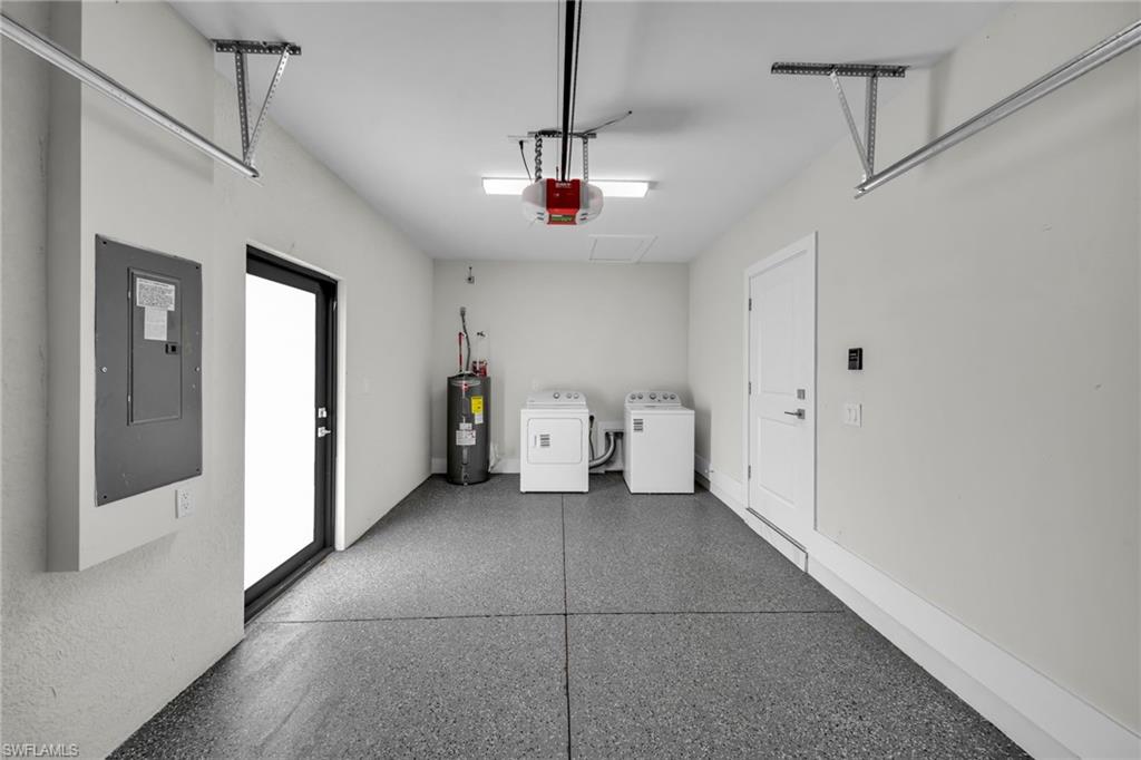 Garage featuring a gray speckled epoxy floor, white walls, and a utility door