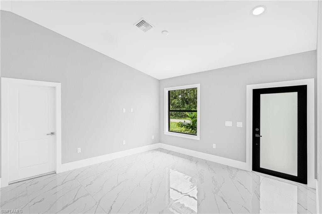 White-finish walls, white trim, and polished tile flooring with a marble-like pattern
