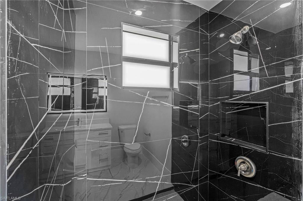 Light gray walls, white trim, recessed lighting, and white marble-look tile flooring