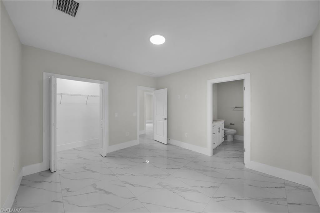 Spacious interior with marble-look tile flooring, white trim, and recessed lighting