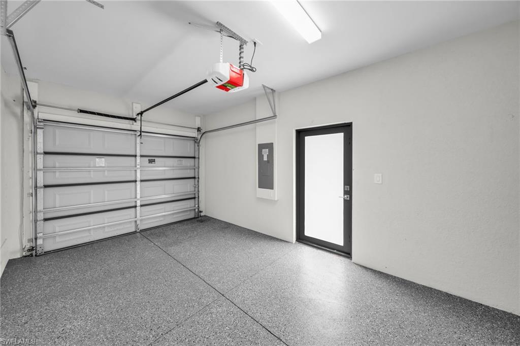 Garage featuring an epoxy floor finish, automatic garage door opener, and a side entry door