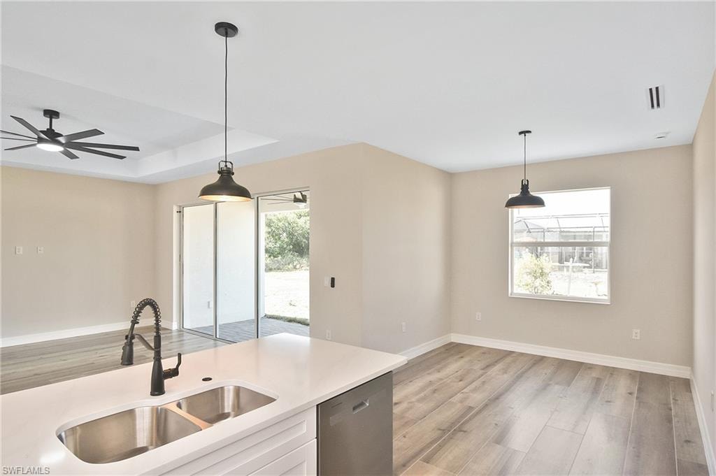 Kitchen island with dual stainless steel sink, pull-down faucet, and white countertop
