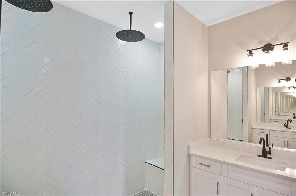 Walk-in shower with herringbone tile, dual rainfall showerheads, and a built-in bench
