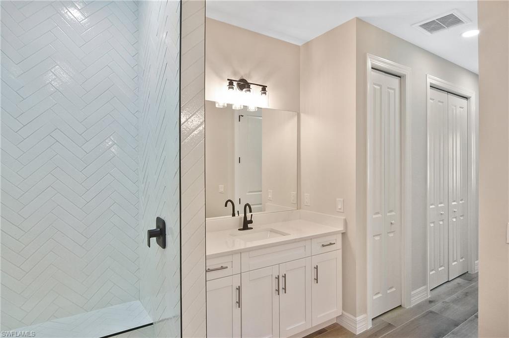 Modern bathroom featuring a glass-enclosed shower with white herringbone tile