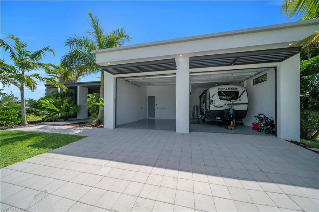 Modern two-bay garage with expansive paved driveway