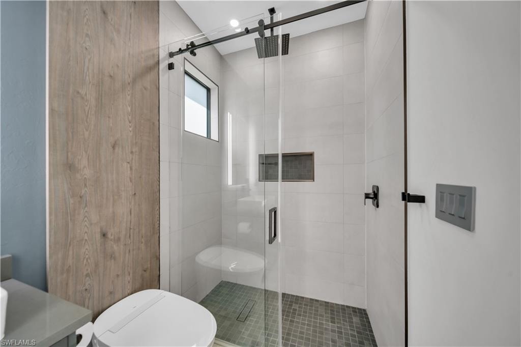 Modern bathroom featuring a glass-enclosed shower with a black-framed sliding door
