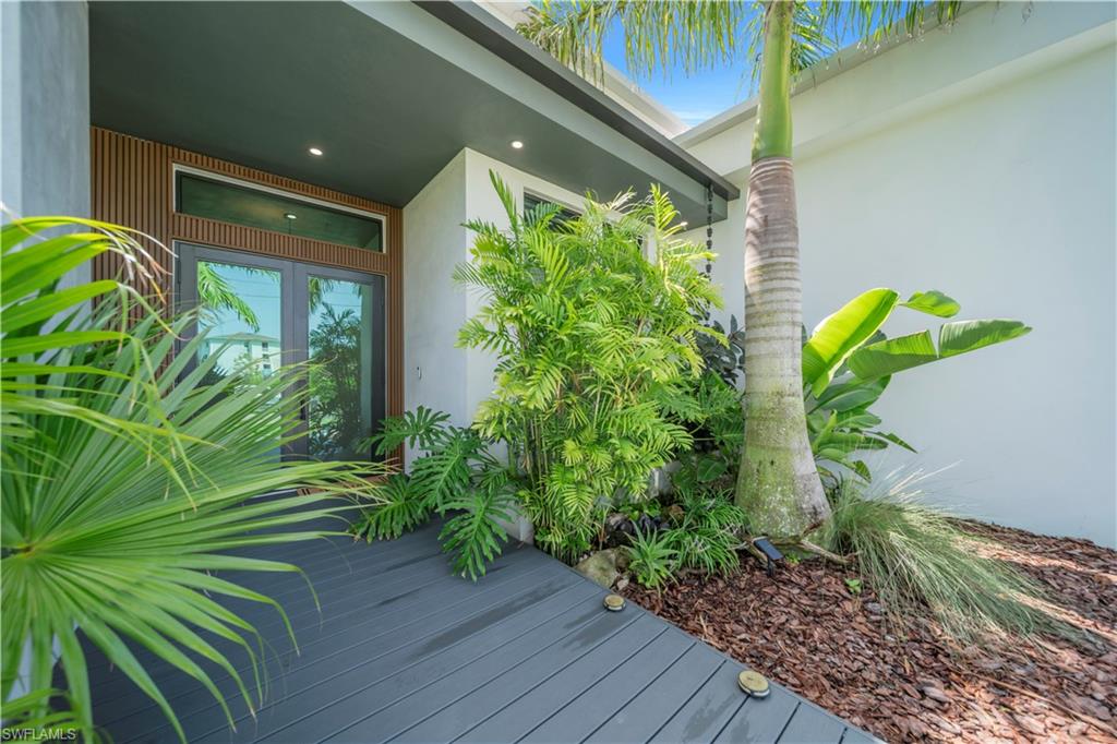 Entryway featuring a dark composite decking path leading to double glass doors with transom windows
